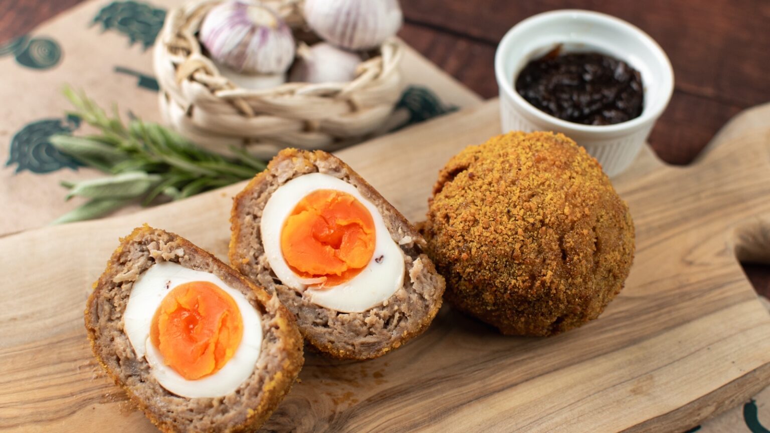 Smoked apple and cinnamon Scotch egg cut open to show its golden yolk and sausage filling